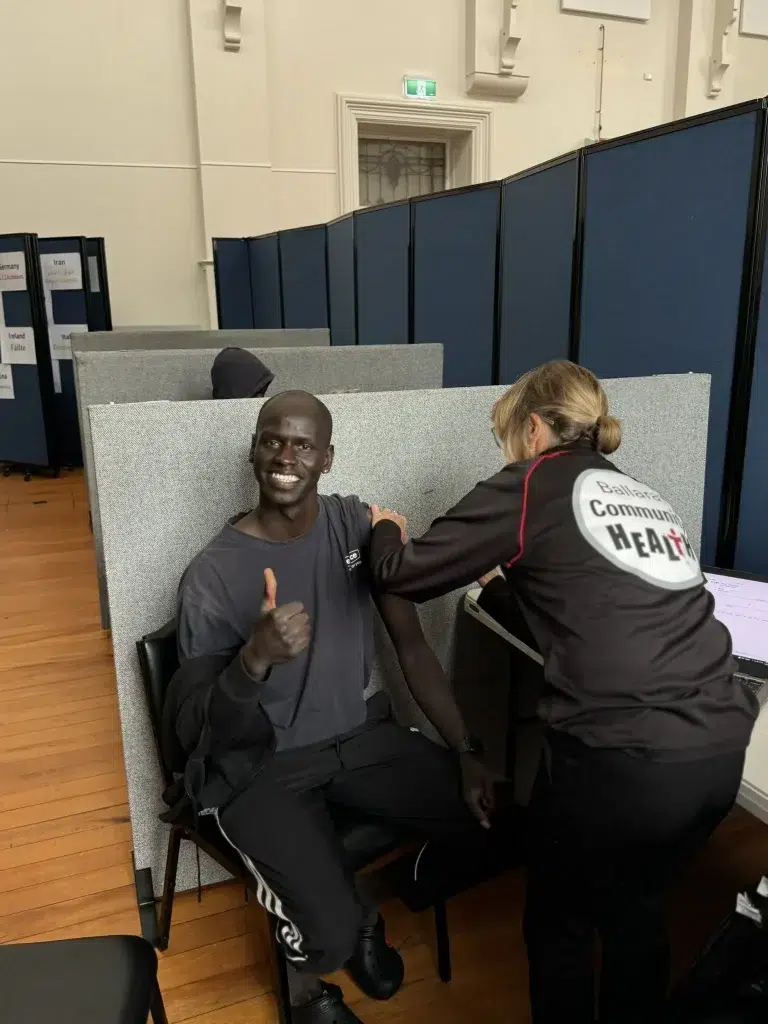 Person receiving vaccination, giving thumbs up.