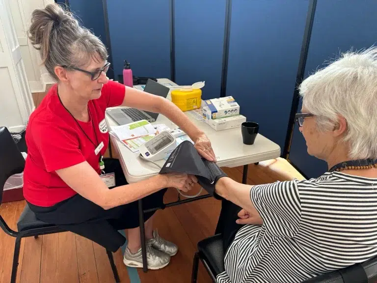 Healthcare worker taking patient's blood pressure.