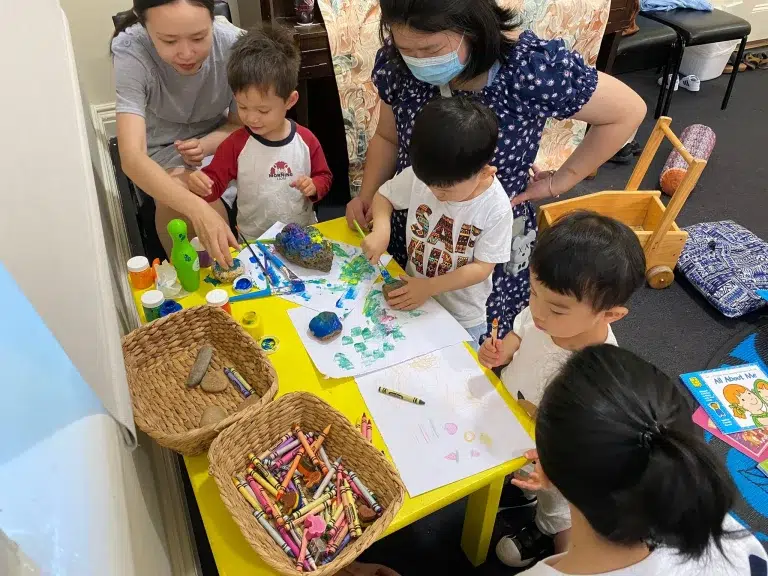 Children creating art with crayons and paint.