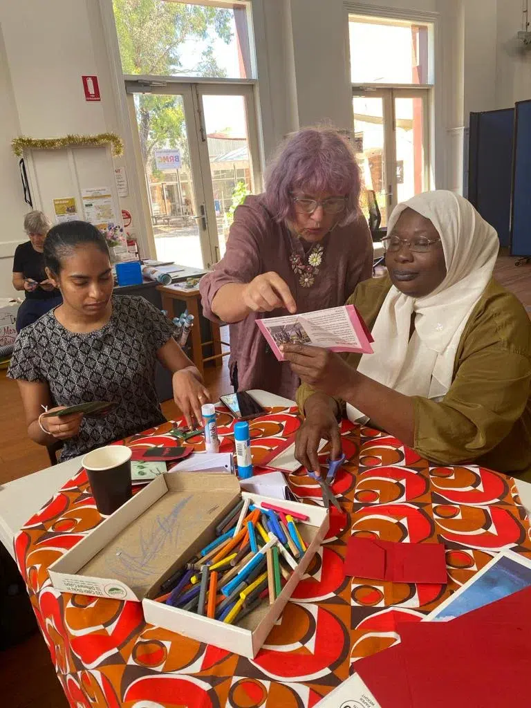 Women crafting together at a table with supplies.