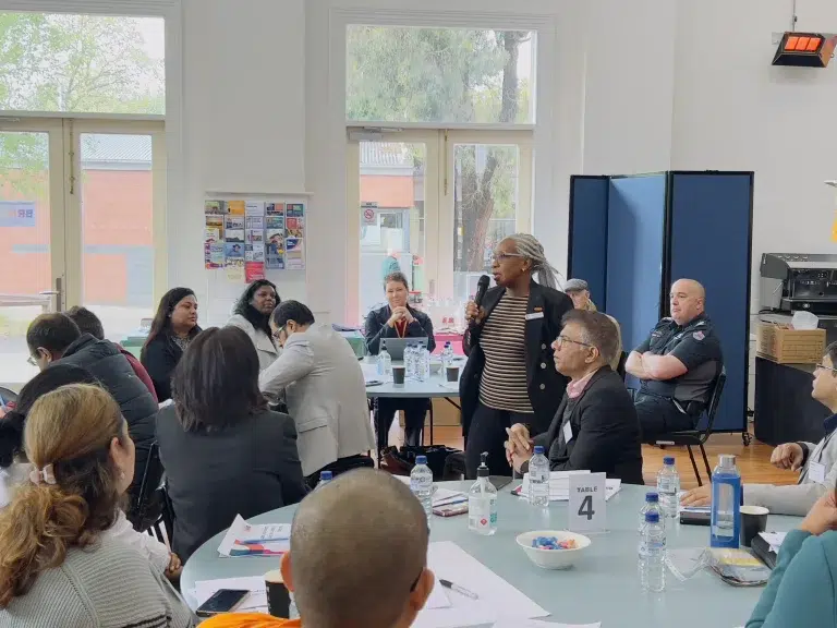 Diverse group meeting in community centre room.