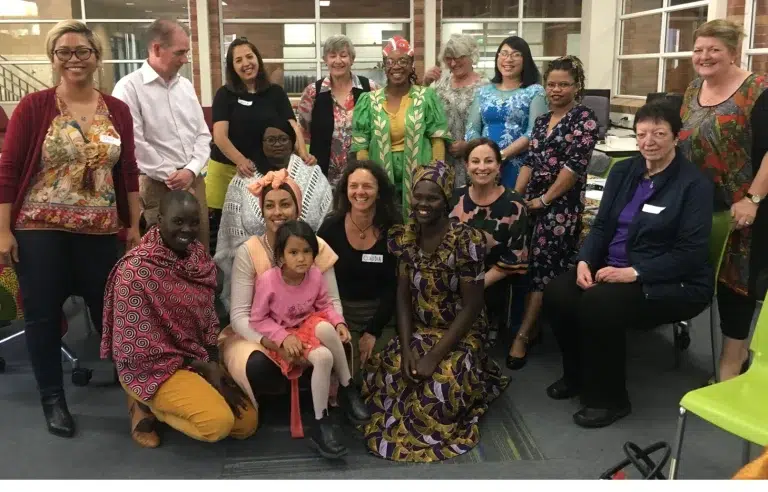 Diverse group gathered indoors for community event.