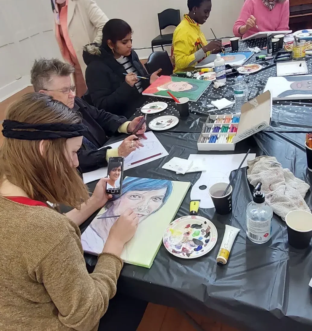 Group painting class with colourful letter decorations.