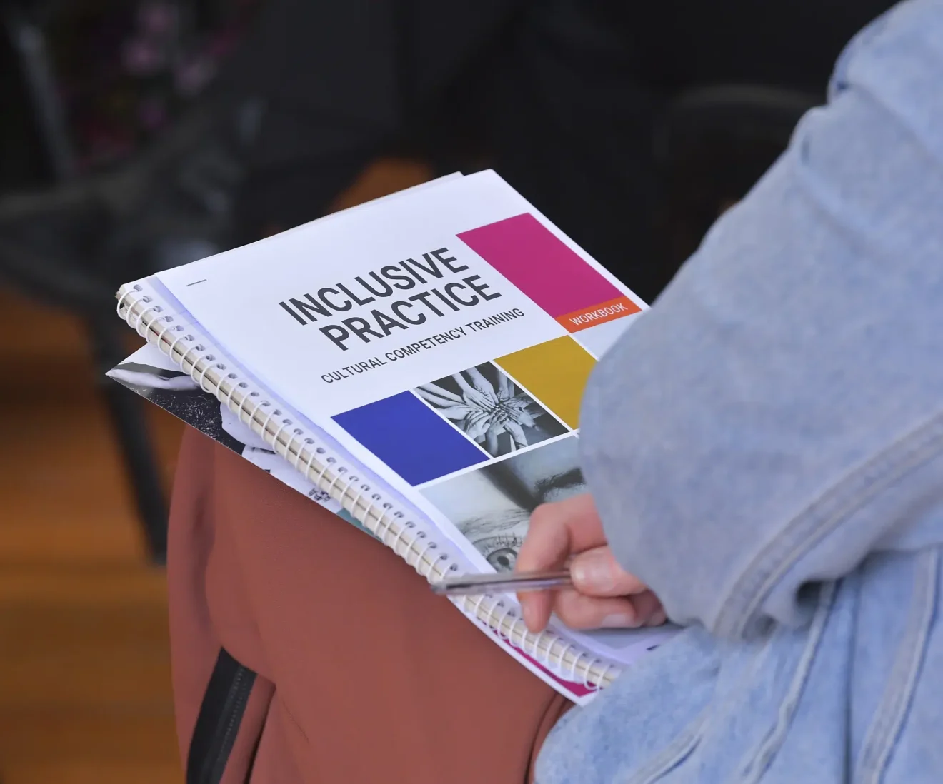 Person holding inclusive practice training workbook.