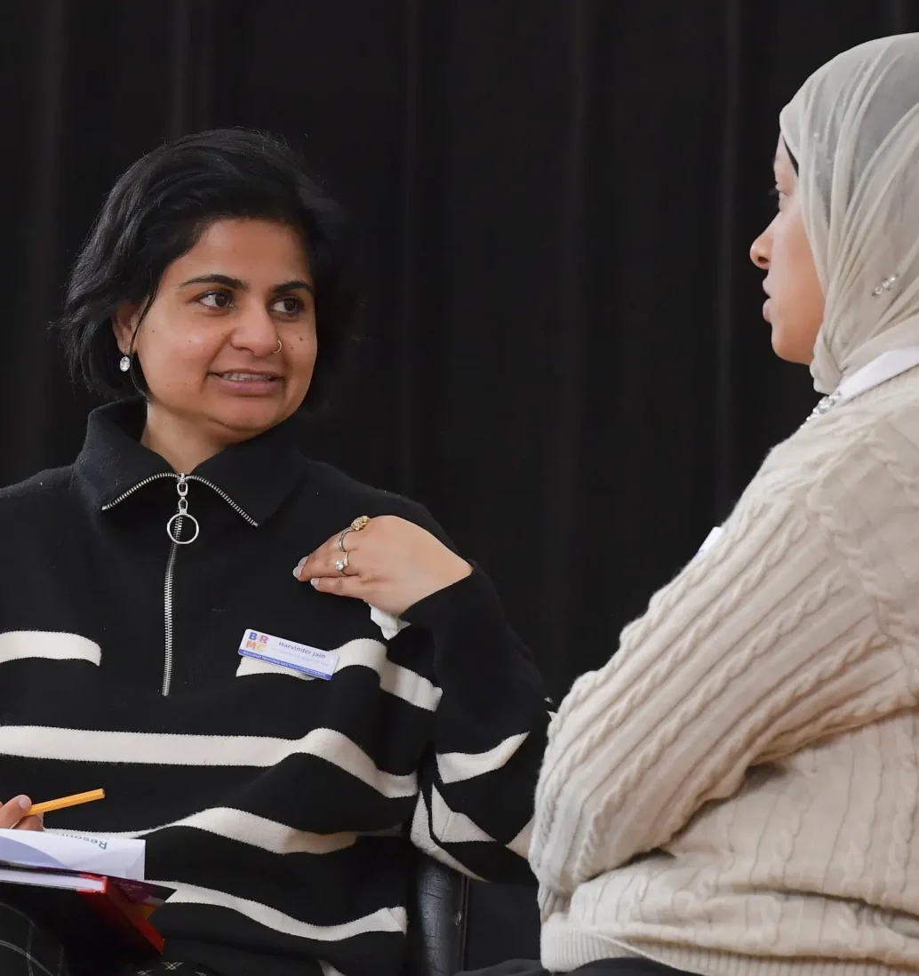 Two women having a discussion indoors.