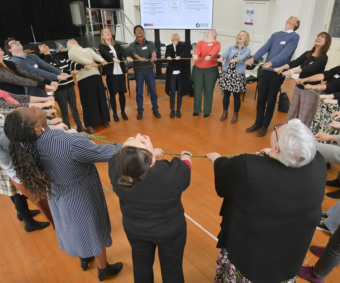 Team-building exercise with a group pulling rope together.