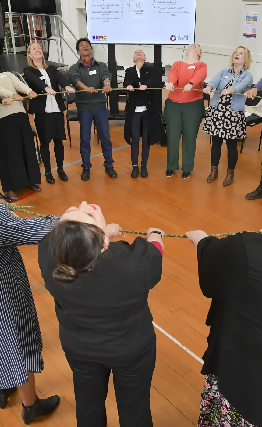Team-building exercise with a group pulling rope together.