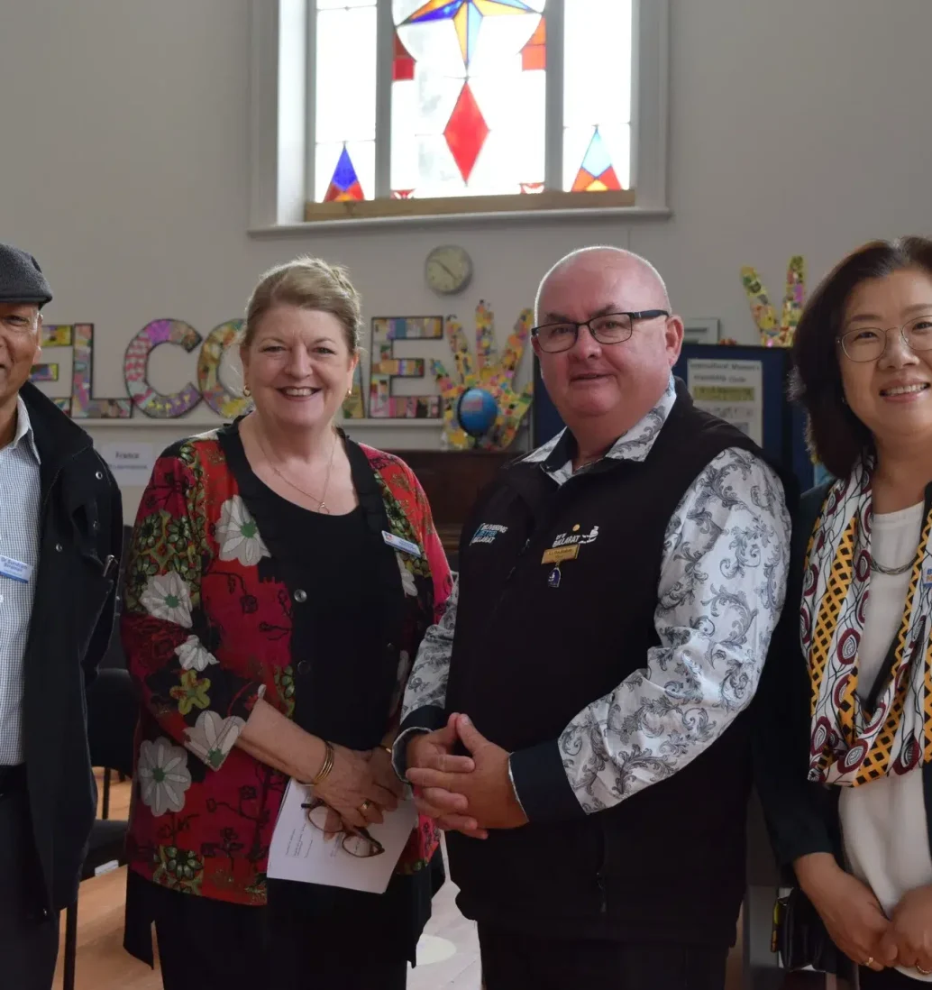 Diverse group smiling at community event indoors.
