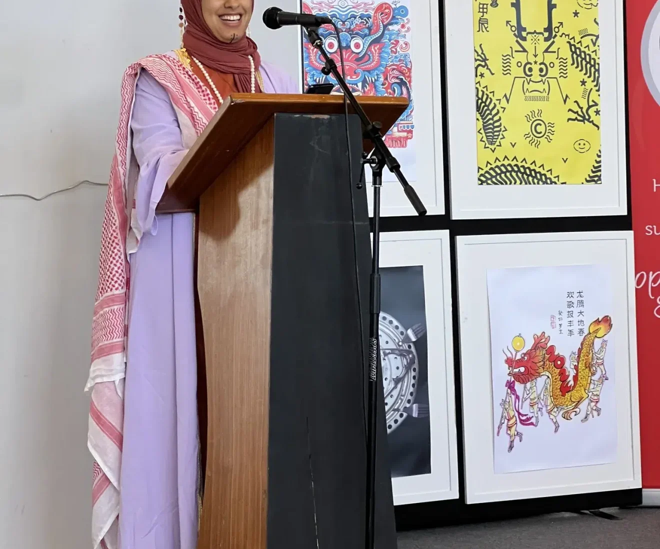Woman in colourful attire speaks at podium.