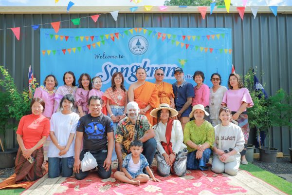 Group celebrating Songkran festival outdoors in traditional attire.