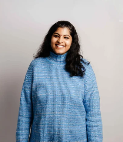 Smiling person in blue sweater, white background