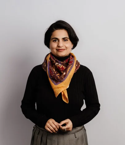 Woman wearing colourful scarf and black sweater.