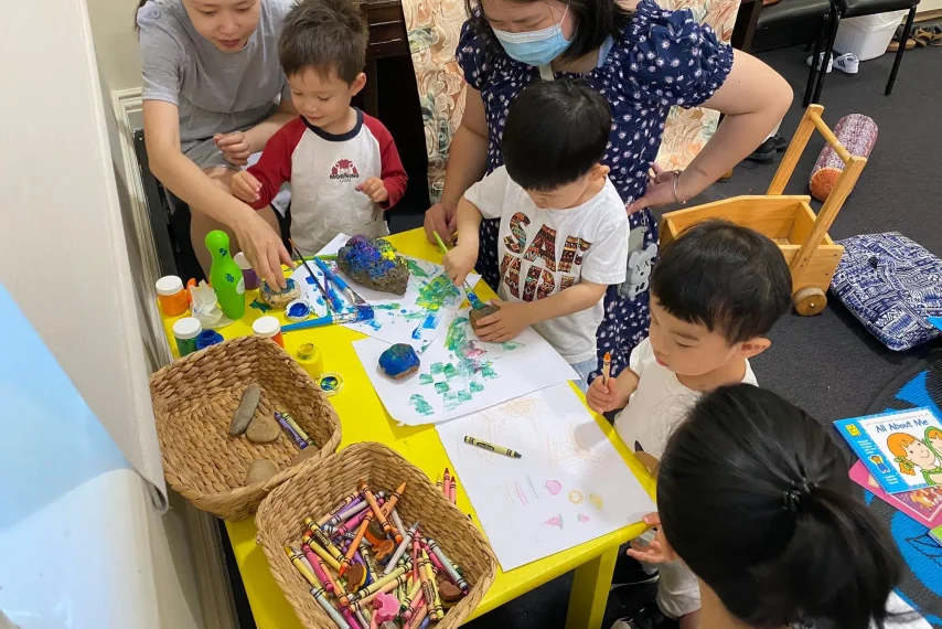 Children creating art with crayons and paint.