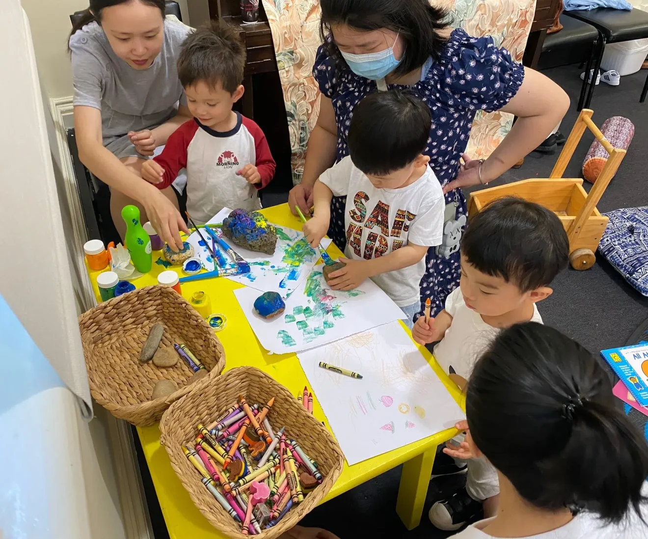 Children creating art with crayons and paint.