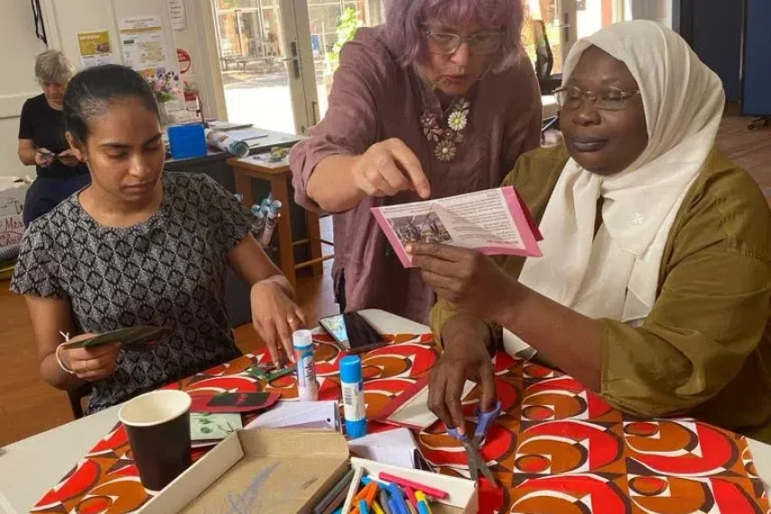 Women crafting together at a table with supplies.