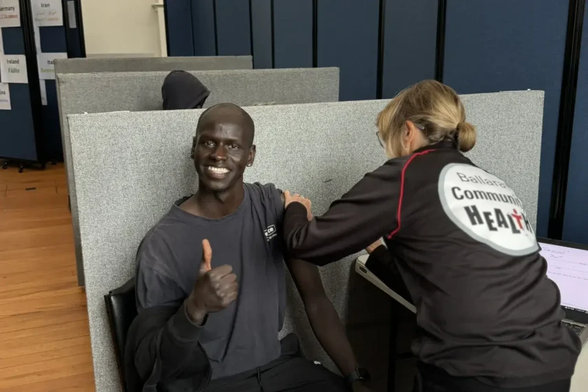 Person receiving vaccination, giving thumbs up.