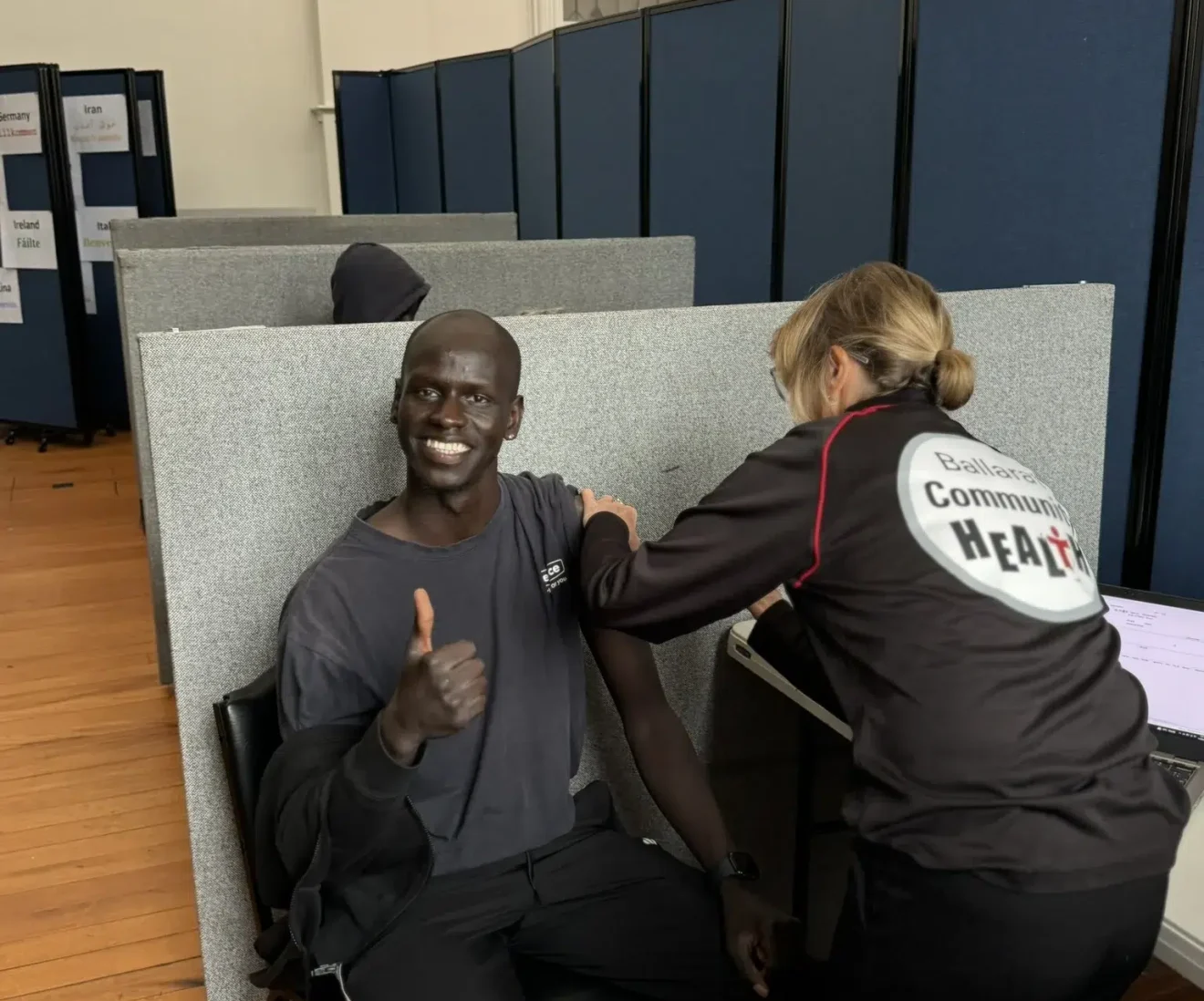 Person receiving vaccination, giving thumbs up.