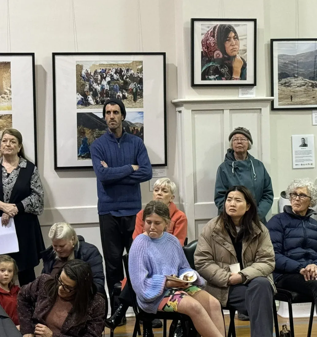 People at exhibition, observing photographs.