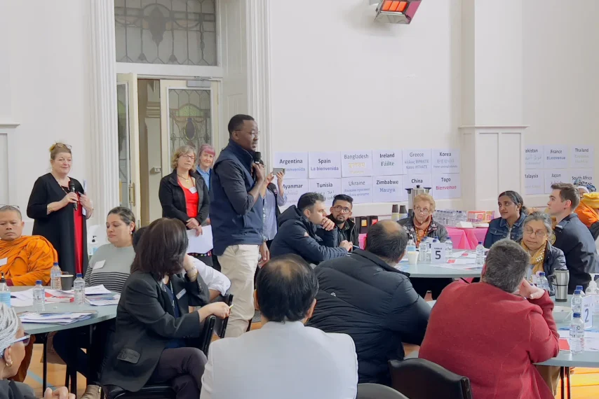 Community meeting with diverse participants speaking.