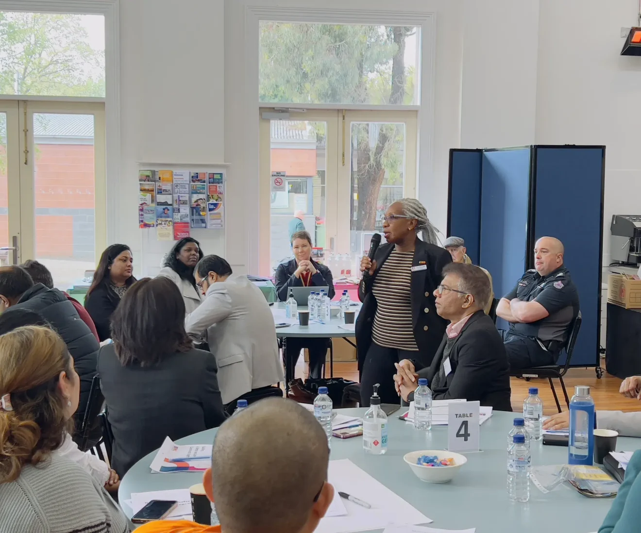 Diverse group meeting in community centre room.