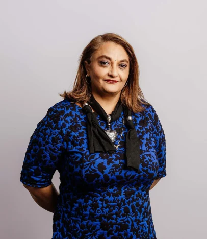 Person wearing blue patterned dress, looking forward.