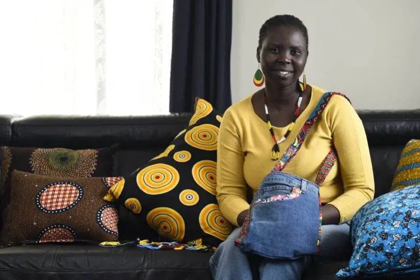 Woman with colourful pillows on couch, smiling.