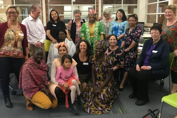 Diverse group gathered indoors for community event.