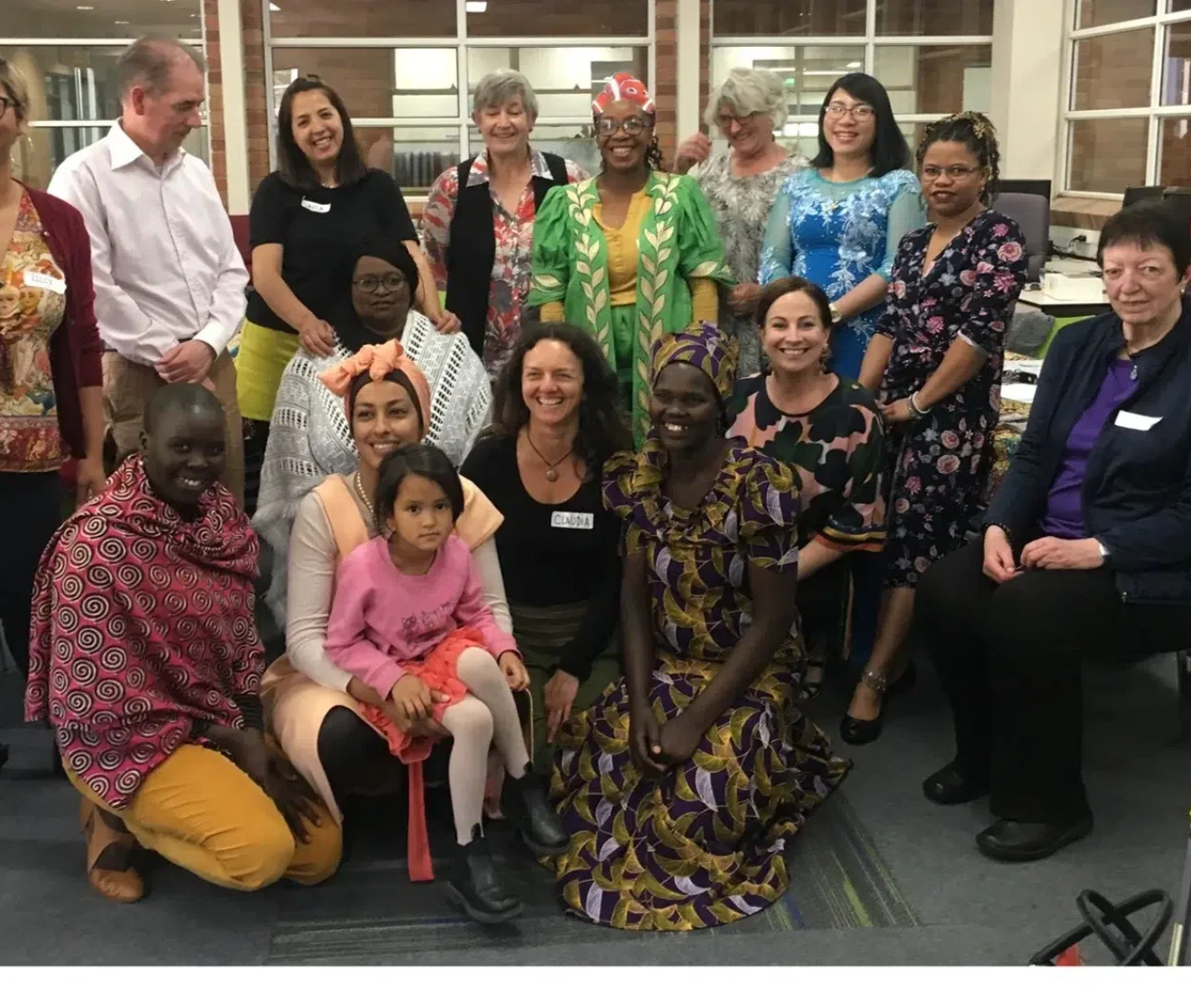 Diverse group gathered indoors for community event.