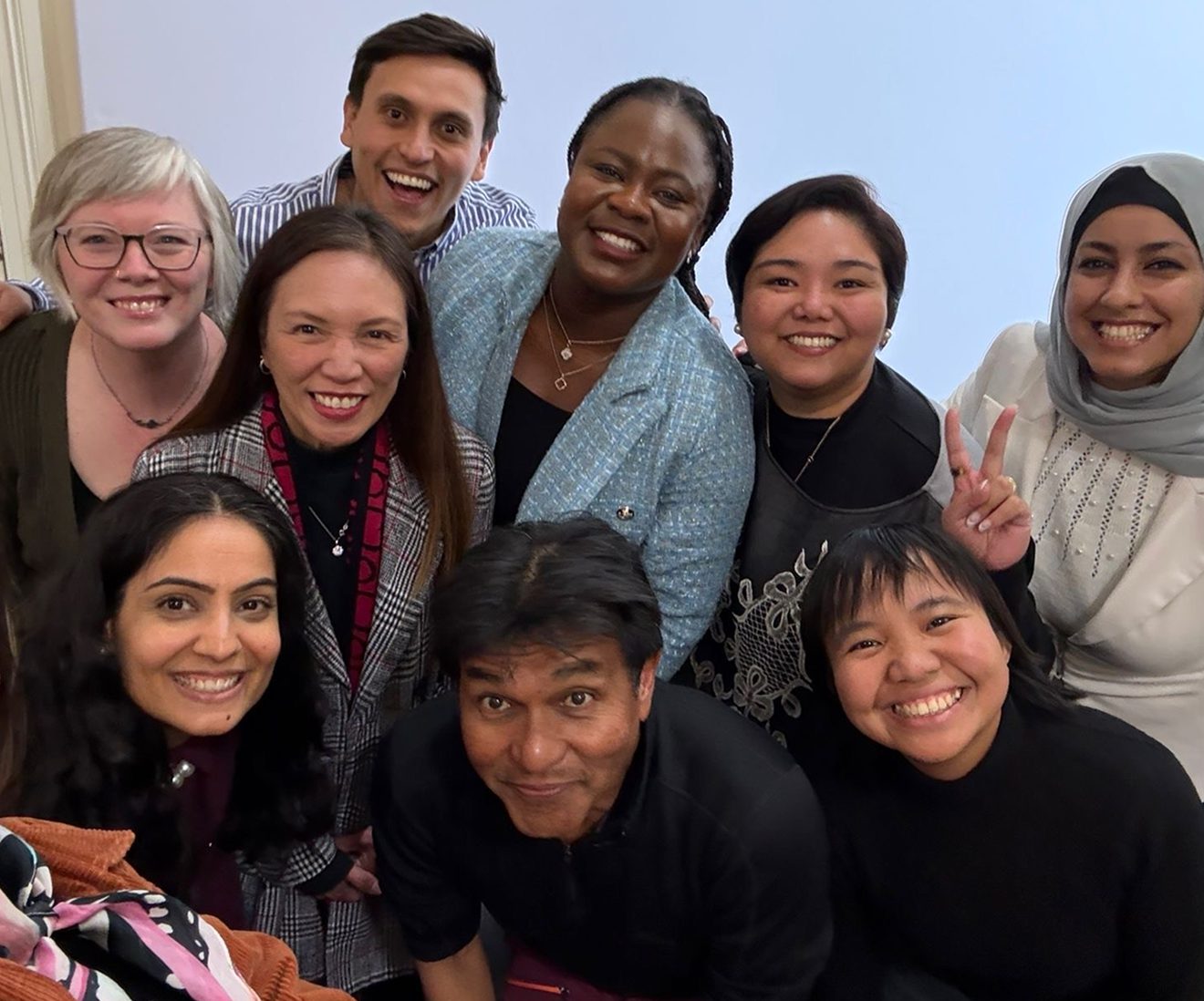 Diverse group of people smiling together indoors.