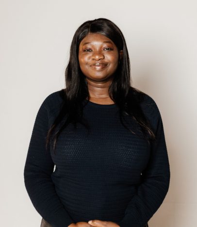 Smiling person in a black jumper posing.