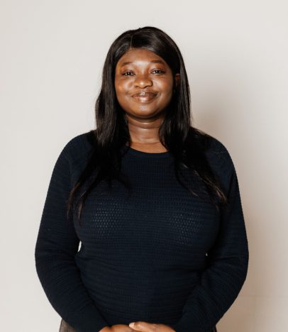Smiling person in a black jumper posing.