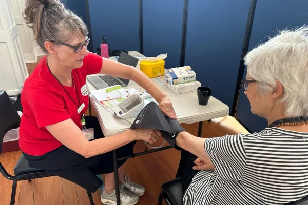 Healthcare worker taking patient's blood pressure.