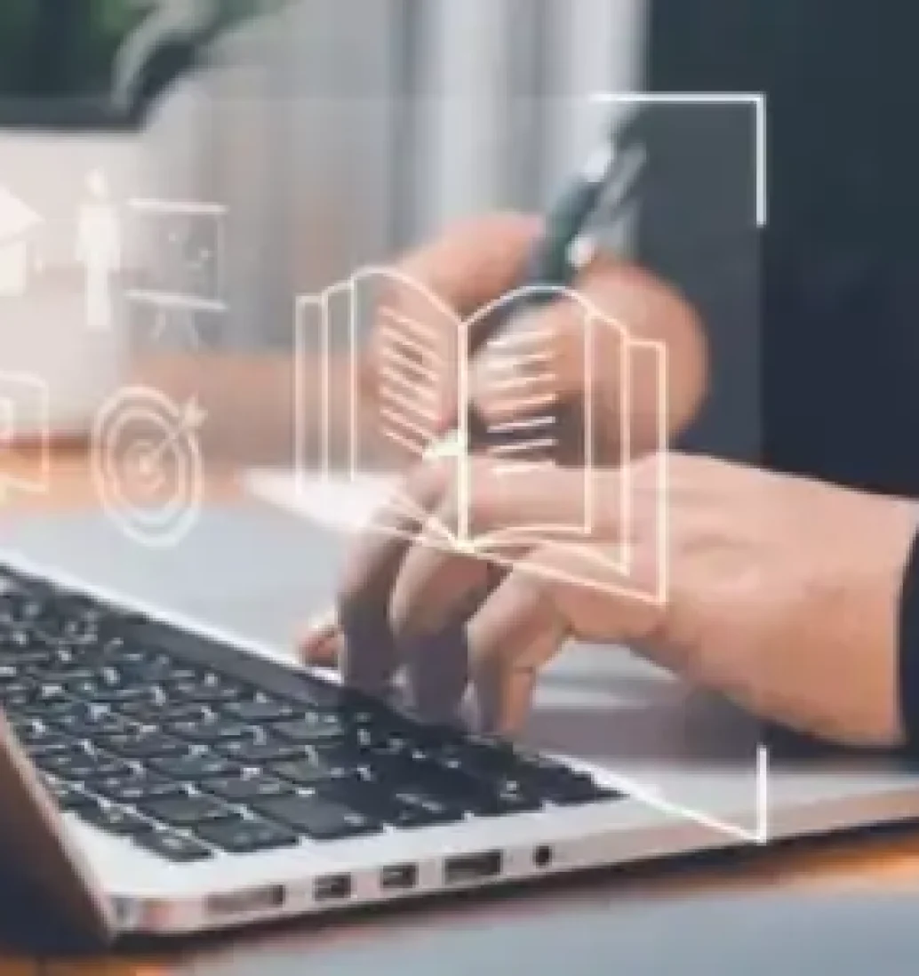 Person typing on laptop with educational icons overlay.