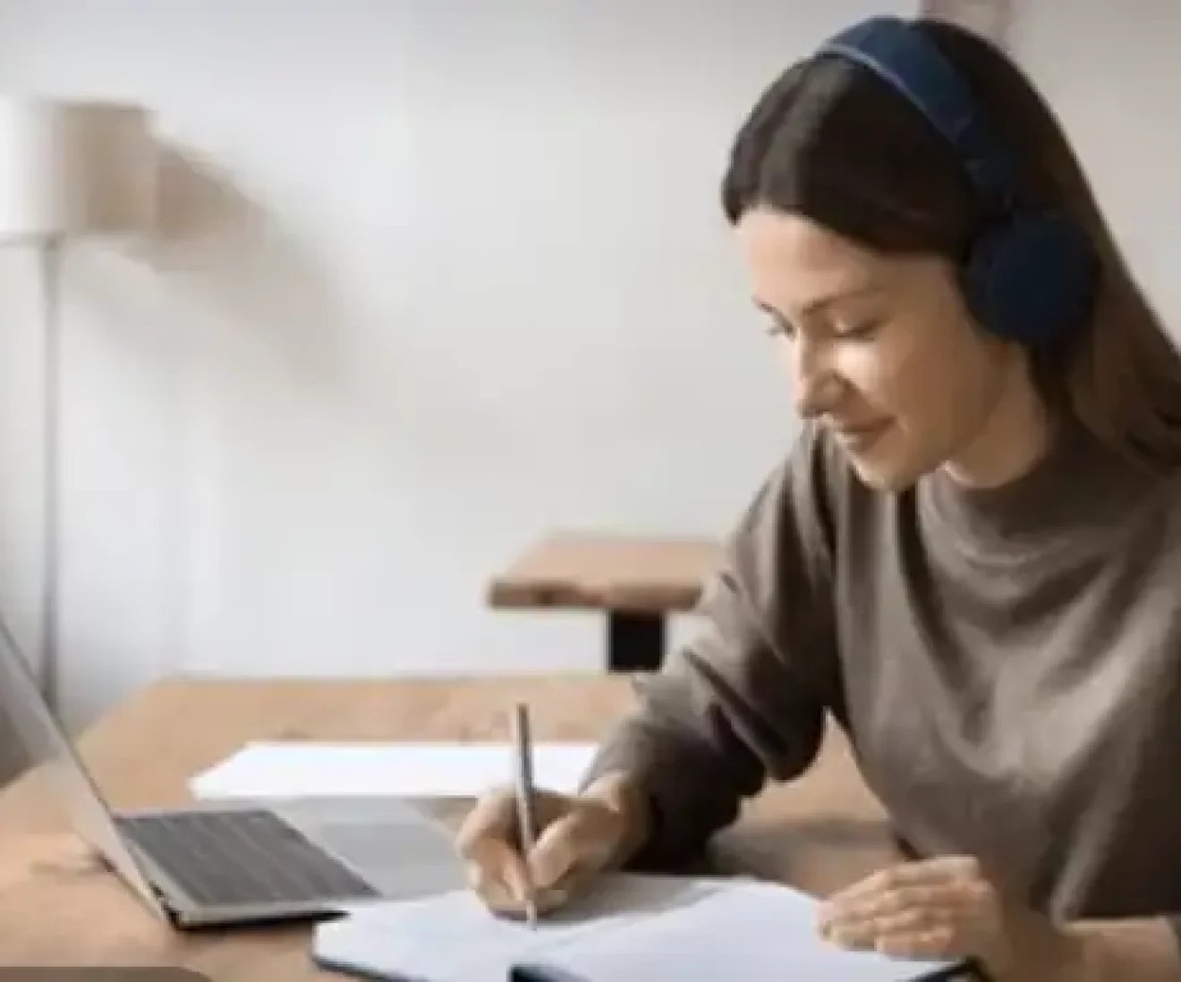 Woman studying with headphones and laptop.